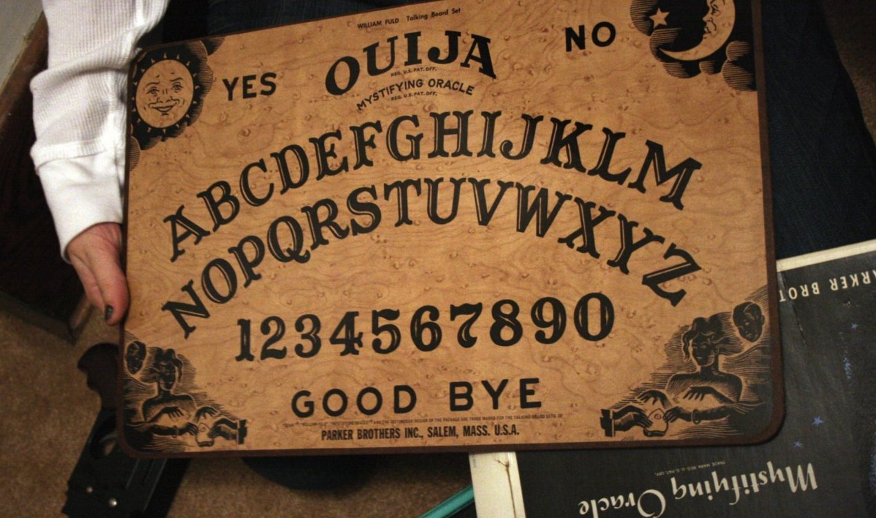 A woman holding a Ouija Board.