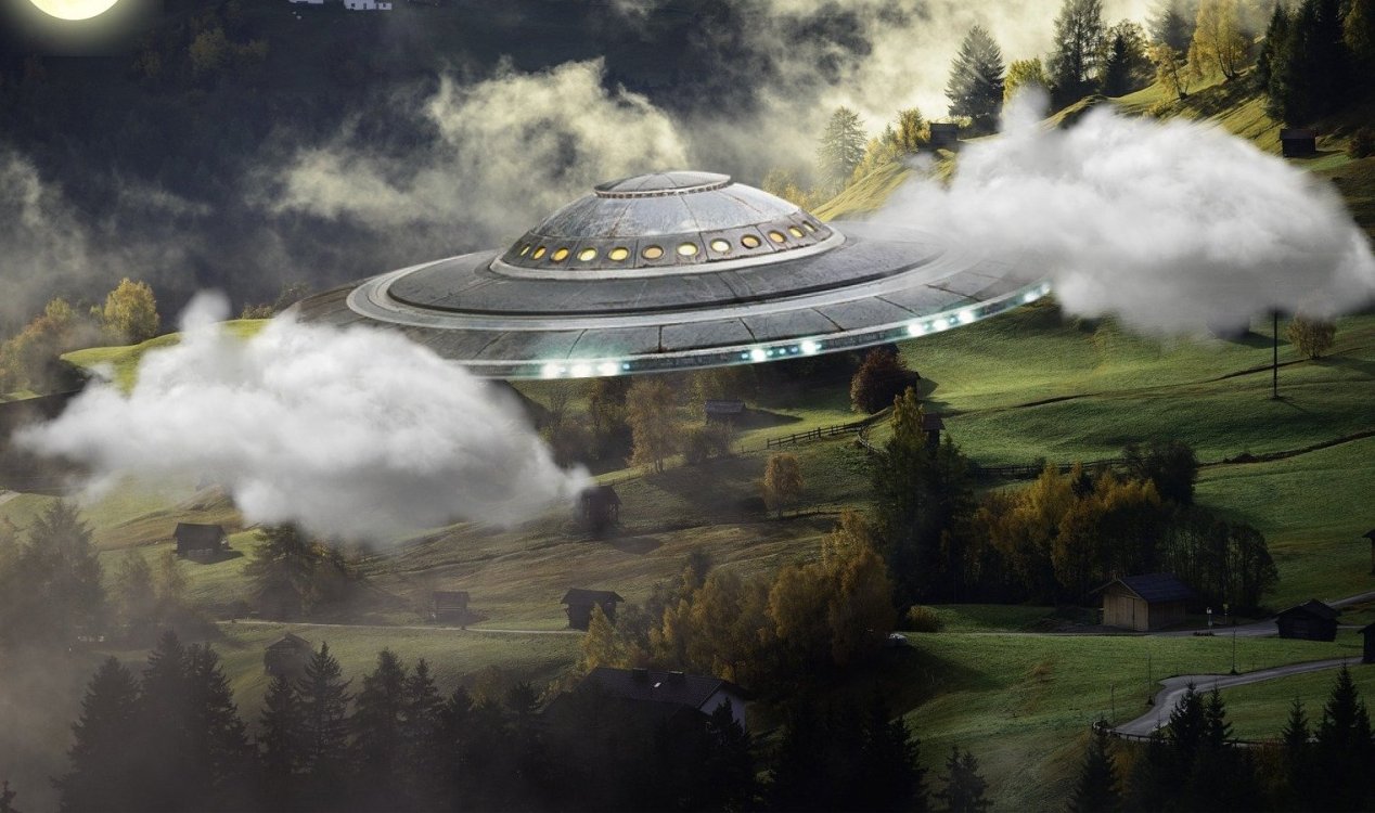 UFO flying through clouds over a grassy landscape.